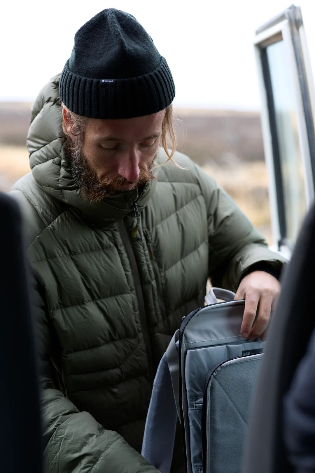 A photographer reaching into a backpack