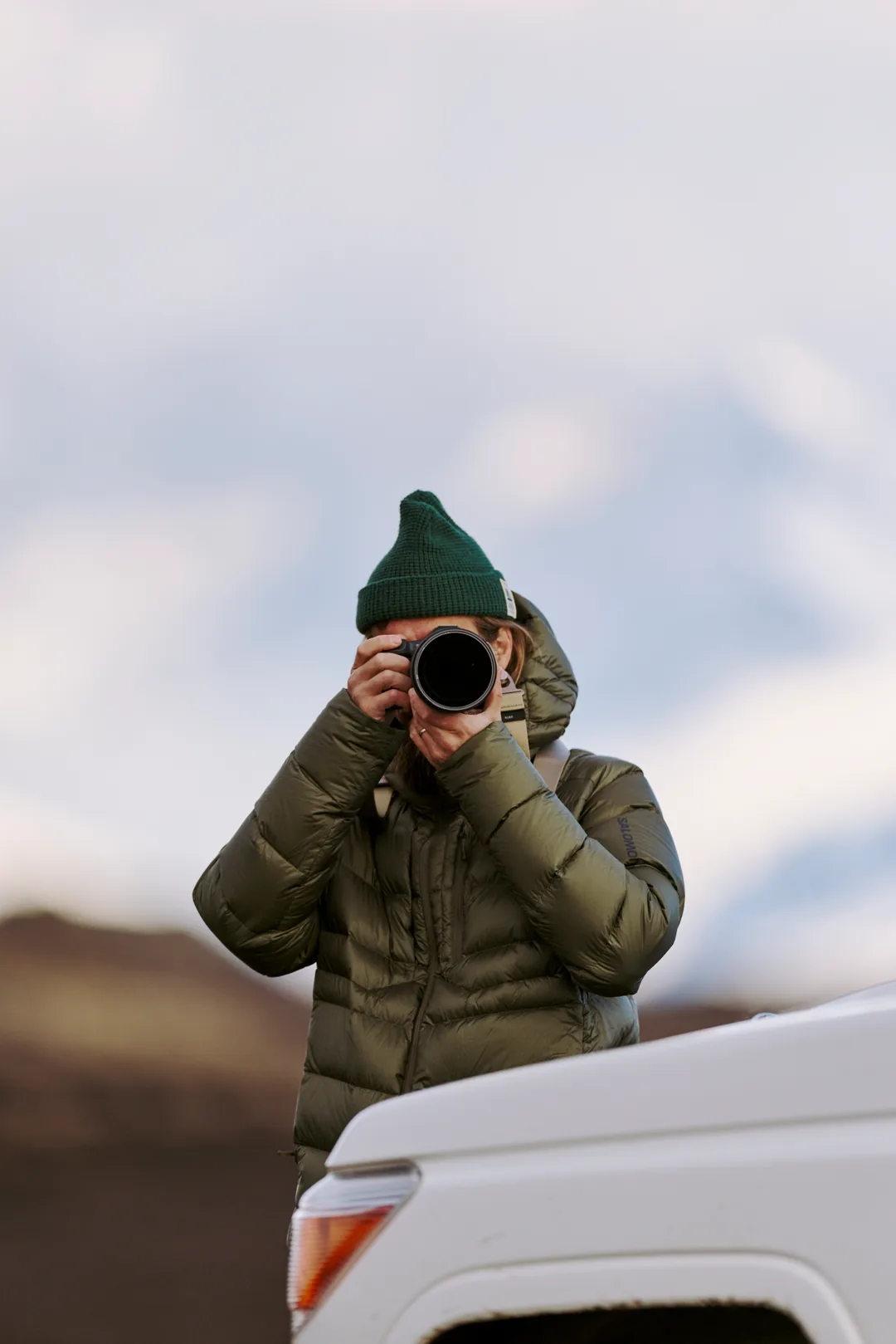 A photographer pointing a camera toward the viewer